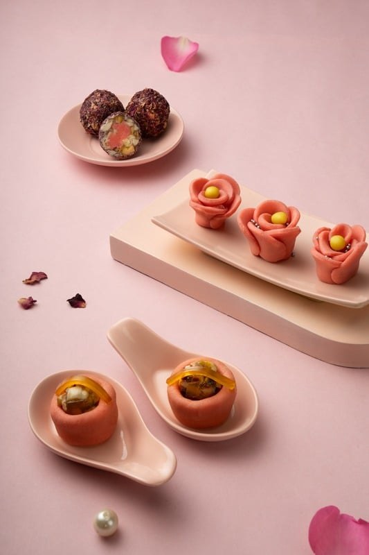 Small decorated sweets arranged on a pale pink background
