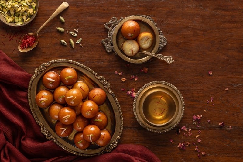 Indian sweets in a bowl with tea and festive table styling